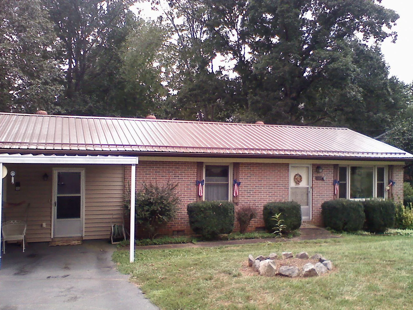 Bronze metal roof and carport on a brick ranch home — Roof Repair work by our crew in Lexington