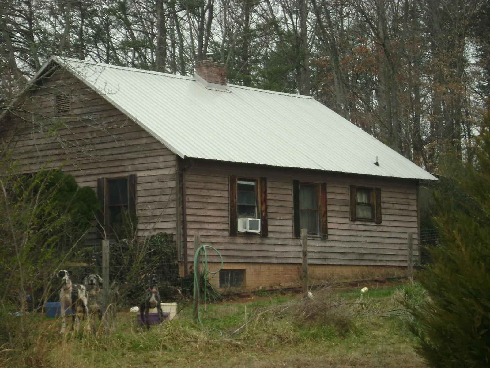 White metal roof on an old wood sided farmhouse, from a Metal Roof Installation job in Lexington